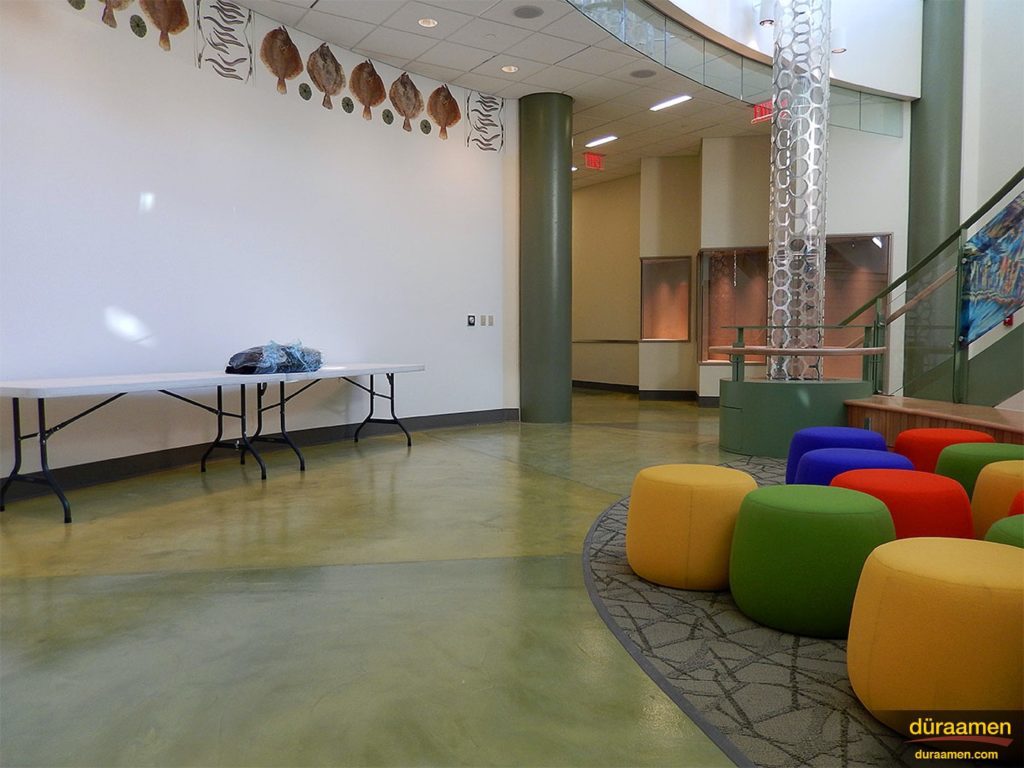 The reflections of the colorful pillow chairs and wall decor can be seen on the high-shine designer flooring.
