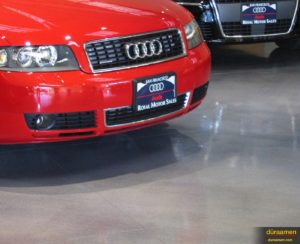 The clean modern resinous flooring of this San Francisco auto dealer let's their cars shine.