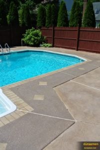 This slip resistant concrete walkway around this swimming pool was resurfaced with Uberdek.
