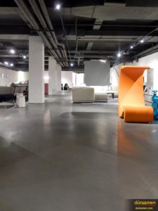 The orange of this designer chair is much brighter thanks to the subtle grey hues of the resurfaced concrete flooring.