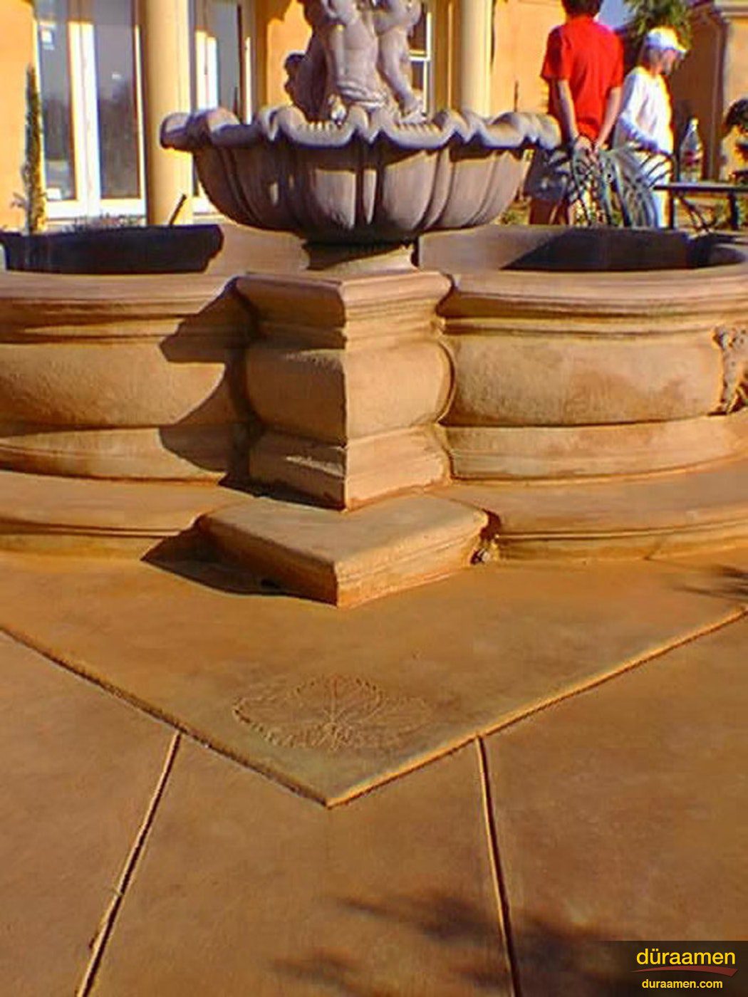 A detail photo of the fountain that was created with a decorative concrete overlay Exterior concrete fountain stained with water based stains | Duraamen Engineered Products Inc