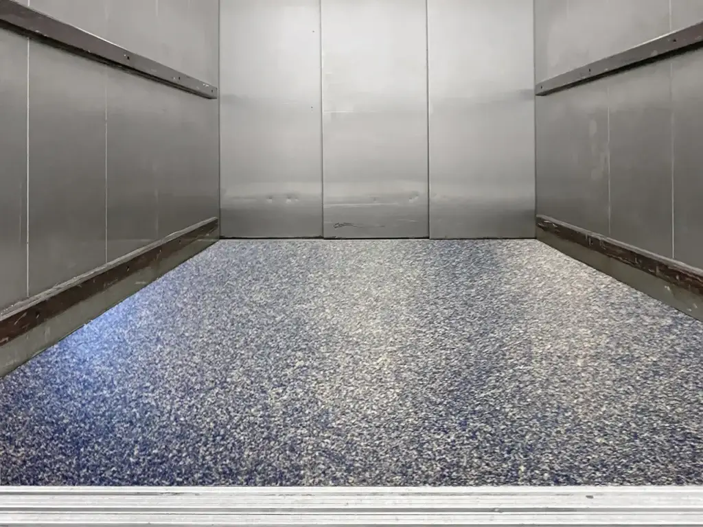 Completed Perdure PU85 freight elevator floor coating with blue and gray Endura decorative resin chip finish sealed with Perdure P90