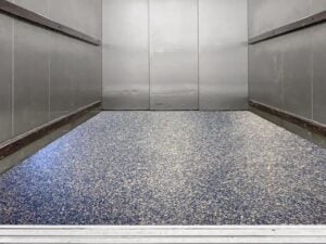 Freight elevator with a polished and seamless epoxy floor coating.