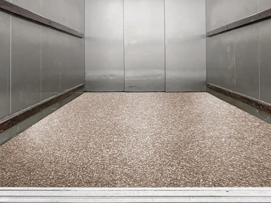 Freight elevator with a glossy and textured epoxy floor coating.