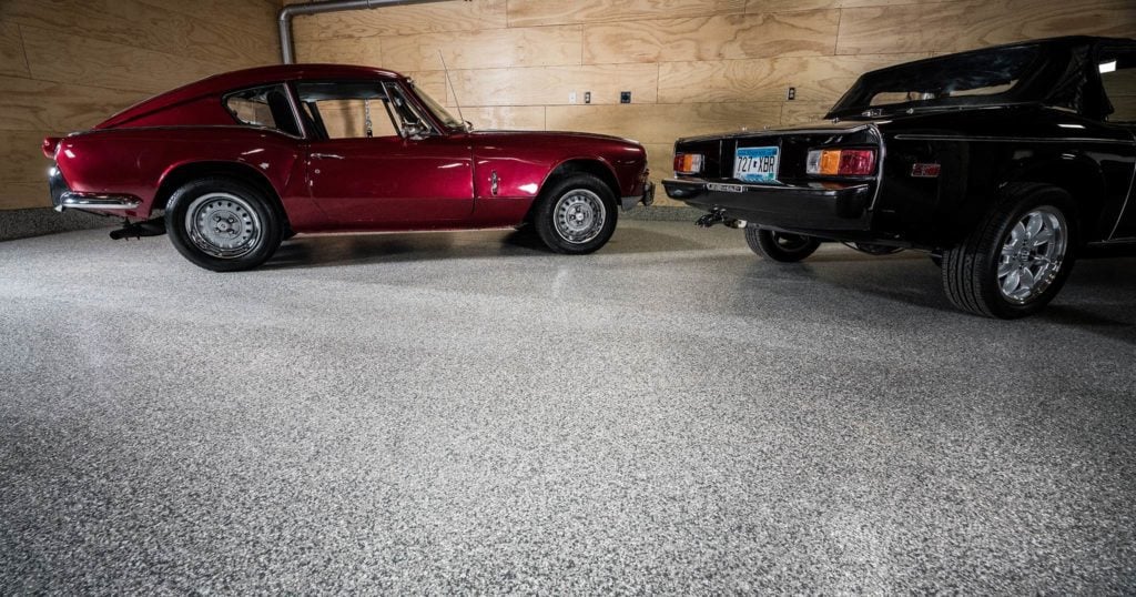 Red sports car parked in a garage with epoxy chip floor coating and non-slip surface.