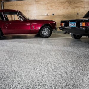 Red sports car parked in a garage with epoxy chip floor coating and non-slip surface.
