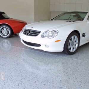 A garage floor coated with epoxy chip floor coating, showcasing a seamless and glossy surface with a blend of colorful decorative chips.