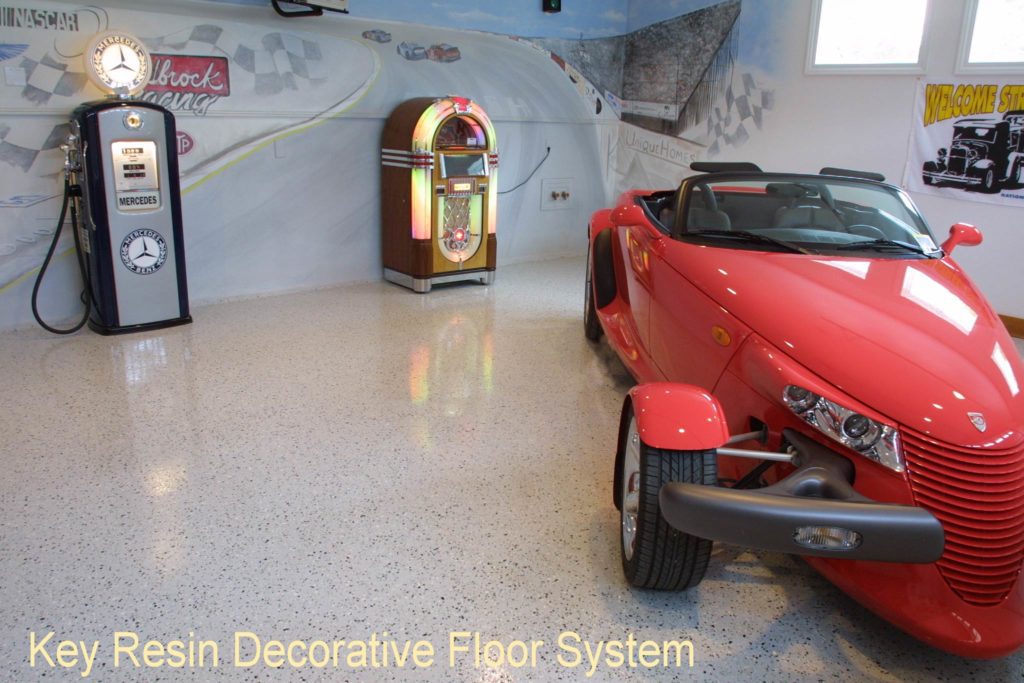 Man cave garage with a red hot rod parked on an epoxy chip floor coating with a non-slip surface.