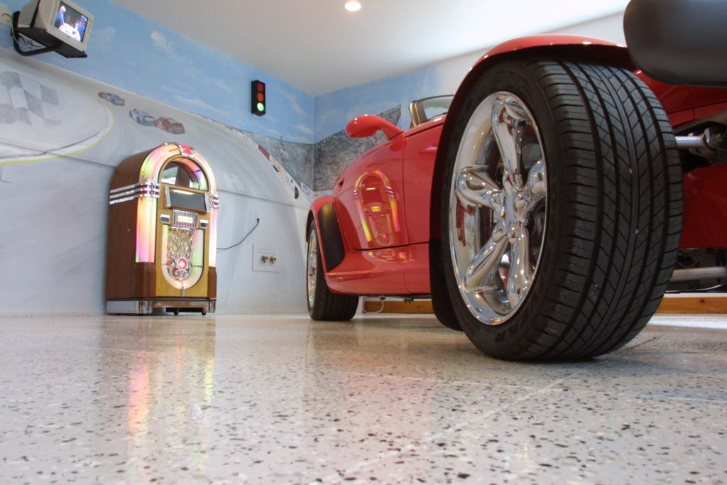 Red hot rod parked in a garage with epoxy chip floor coating and non-slip surface.