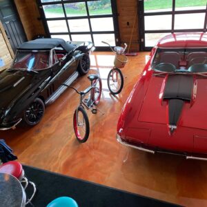 Metallic epoxy garage floor with a red and black corvettes parked