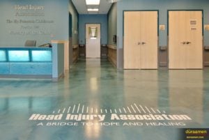 The logo of the head injury medical center appears on the metallic epoxy flooring.
