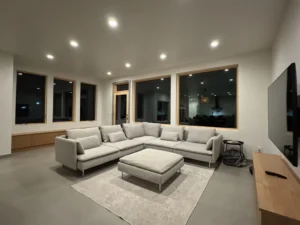 Modern living room with light gray Arapido microcement flooring and sectional sofa.