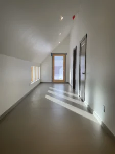 Entryway with large glass door and seamless Arapido flooring.