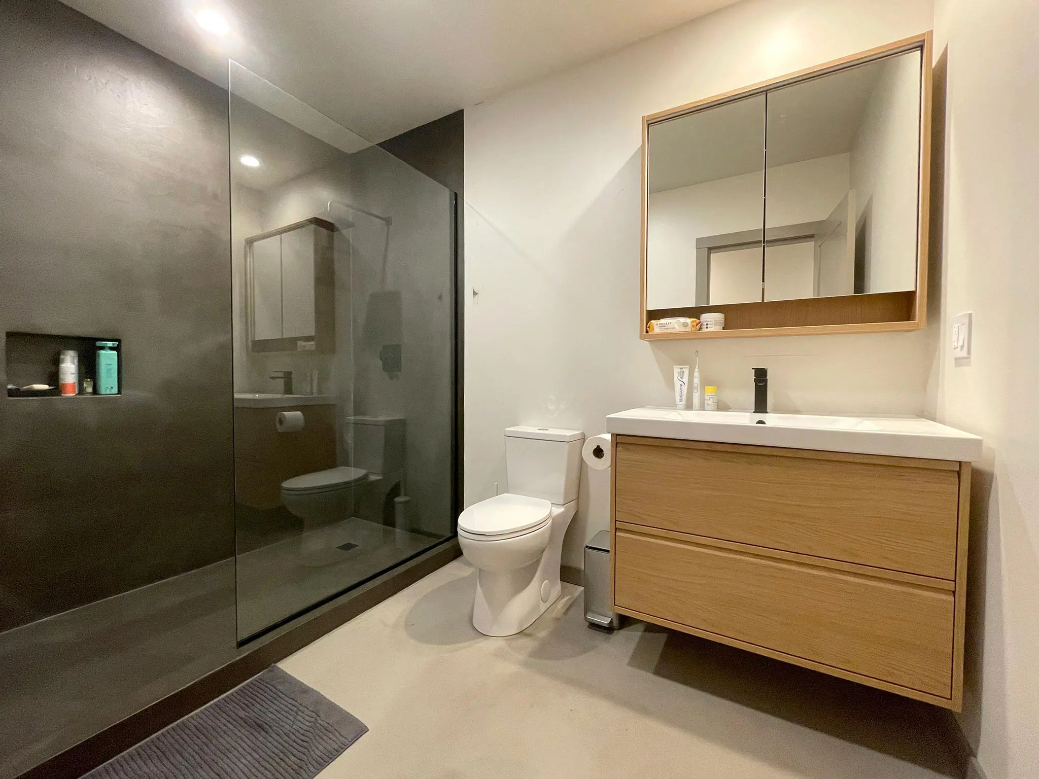 Residential bathroom with microcement flooring and shower.