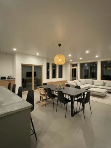 Dining area with pendant light, large windows, and Arapido microcement floor.image 2