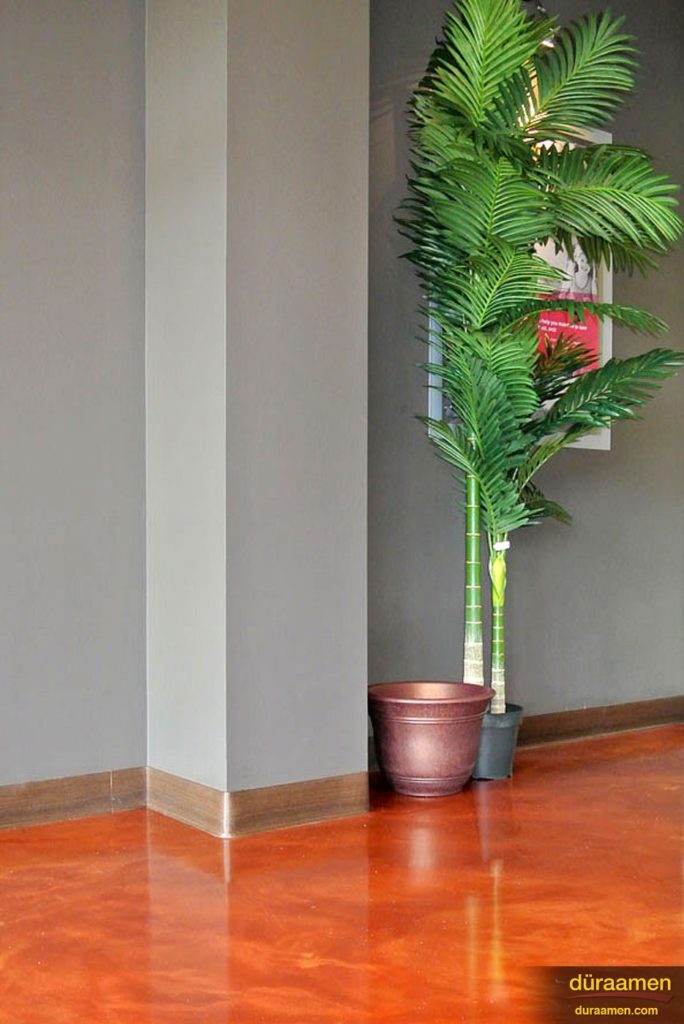 The high gloss copper-orange color of the metallic epoxy floor cantrasts nicely against the gray walls.