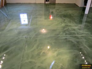 The deep green hues are evident in this photos of a building entrance that had its floor enhanced with metallic epoxy.