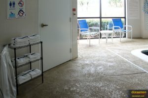 This close up shows the texture of the flooring around the pool deck. Spray-texture concrete flooring overlays can achieve varied aesthetics depending upon the installation technique.
