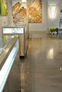 A detailed view of a polished concrete floor showcasing a mirror-like, reflective finish with a seamless and smooth surface.