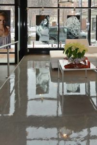 A polished concrete floor with a glossy finish, featuring intricate white and gray vein-like patterns.