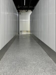 Duraamen's epoxy floor coating and resin chips with a polyaspartic topcoat used as the flooring in this self storage facility. Hallway photo 5.