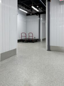 Duraamen's epoxy floor coating and resin chips with a polyaspartic topcoat used as the flooring in this self storage facility. Hallway photo 2.