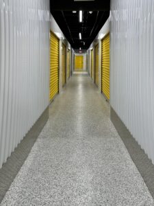 Duraamen's epoxy floor coating and resin chips with a polyaspartic topcoat used as the flooring in this self storage facility. Hallway photo.