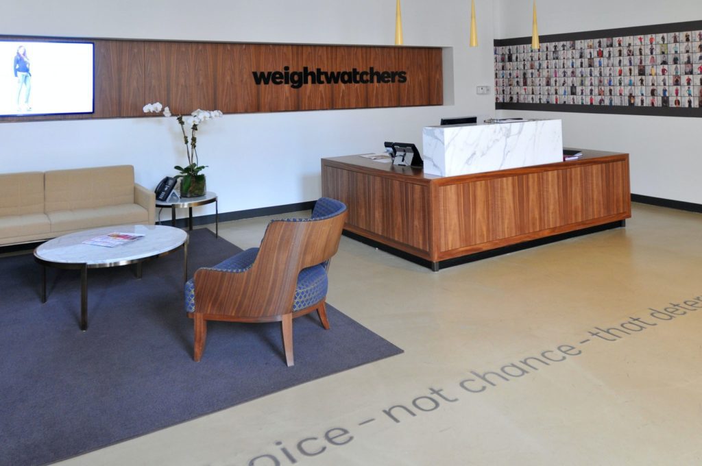 Close-up of a sleek and glossy polished concrete floor in a Weight Watchers office, featuring subtle variations in shades of gray.