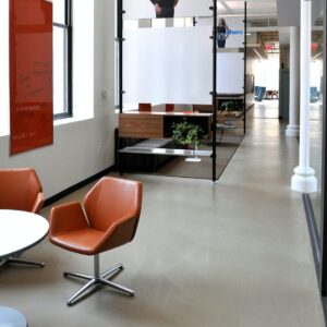A close-up of Weight Watchers office flooring, displaying a polished concrete surface adorned with embedded logos and vibrant colors.